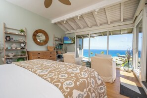 A bedroom with a large bed, a TV, a wooden dresser, and a view of the ocean. - Kapalua Bay | Ocean View 3 BR, Sleeps 10 | Car Incl. w/ 6+ Nights | KBV ML-1963 by KBM (Lahaina)