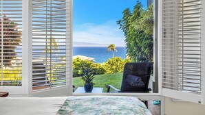 A bedroom with a view of the ocean, a chair, and a small table. - Kapalua Bay | Ocean View 3 BR, Sleeps 10 | Car Incl. w/ 6+ Nights | KBV ML-1963 by KBM (Lahaina)