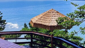 Ein Gebäude mit einem Reetdach und Blick auf das Meer.