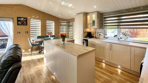 Una cocina moderna con armarios de madera, una isla central y una zona de comedor con sofá.