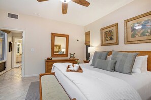 A bedroom with a large bed, a wooden dresser, a mirror, and two framed pictures on the wall. - Kapalua Bay | Ocean View 6 BR, Sleeps 20 | Car Incl. w/ 6+ Nights | KBV ML-1978 by KBM (Lahaina)