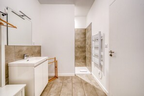 A modern bathroom with a white sink, mirror, and towel rack. - Nice flat in Bordeaux-Saint-Jean (Bordeaux)