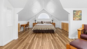 A bedroom with a sloped ceiling, a large bed, a desk, and a chair. - Jed Smith Cabin with Tennis/Pickle ball courts and HOT TUB! (Crescent City)