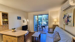A compact living space with a kitchenette, a sofa, a TV, and a dining area with a table and chairs. - Ground-floor studio, air conditioning, close to the sea, parking (ST MANDRIER SUR MER)