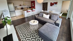 Eine moderne Wohnung mit Wohnzimmer, Küche und Essbereich.