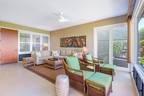 A spacious living room with a sofa set, rattan chairs, a coffee table, and a ceiling fan. - Kapalua Bay | Ocean View 2 BR, Sleeps 8 | Car Incl. w/ 6+ Nights | KBV ML-1996 by KBM (Lahaina)