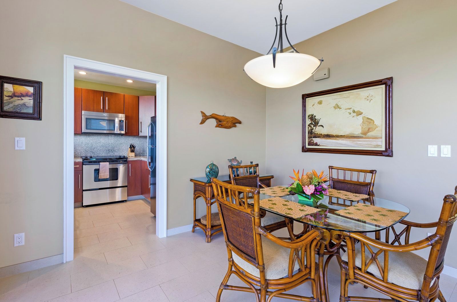 A dining area with a glass table, wicker chairs, and a decorative centerpiece.