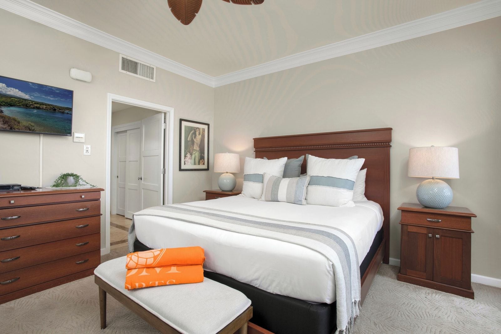 A bedroom with a bed, bedside tables, a dresser, and a bench.