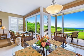 A dining area with a glass table, wicker chairs, and a view of the ocean. - Kapalua Bay | Ocean View 3 BR, Sleeps 10 | Car Incl. w/ 6+ Nights | KBV ML-2014 by KBM (Lahaina)