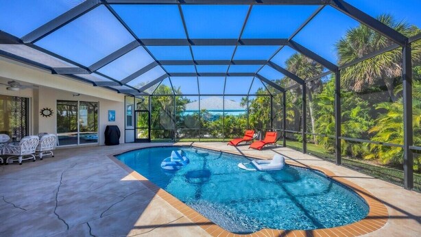 Ein überdachter Außenpool mit Liegestühlen und einer Terrassenfläche.