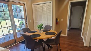 Un comedor con una mesa redonda, cuatro sillas y una planta en maceta.