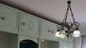 A room with two beds, a wardrobe, and a chandelier. - Elegant 2-Bedroom Apt with City View in Agouza. (Giza Governorate)