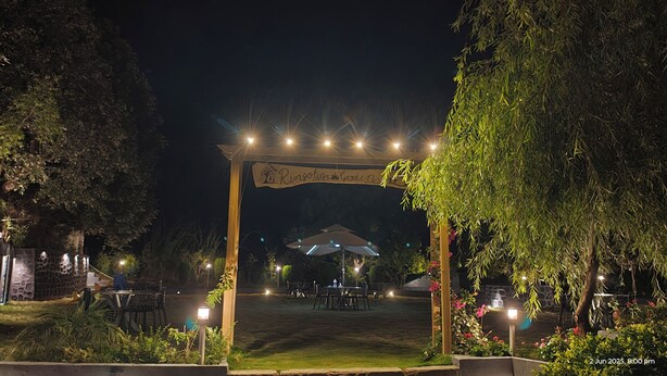 An outdoor dining area with a wooden archway labeled "Ringlot Garden" and tables under umbrellas. - Kumaoni Karavan Camps Resort (Nainital)