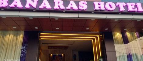 Der Eingang des Banaras Hotels mit einer Neonreklame und einem modernen Innenraumdesign.
