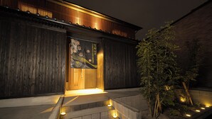 A traditional wooden building with a wooden door and steps leading up to it, illuminated by ground lights. - TAKENOYADO BEPPU (Beppu)