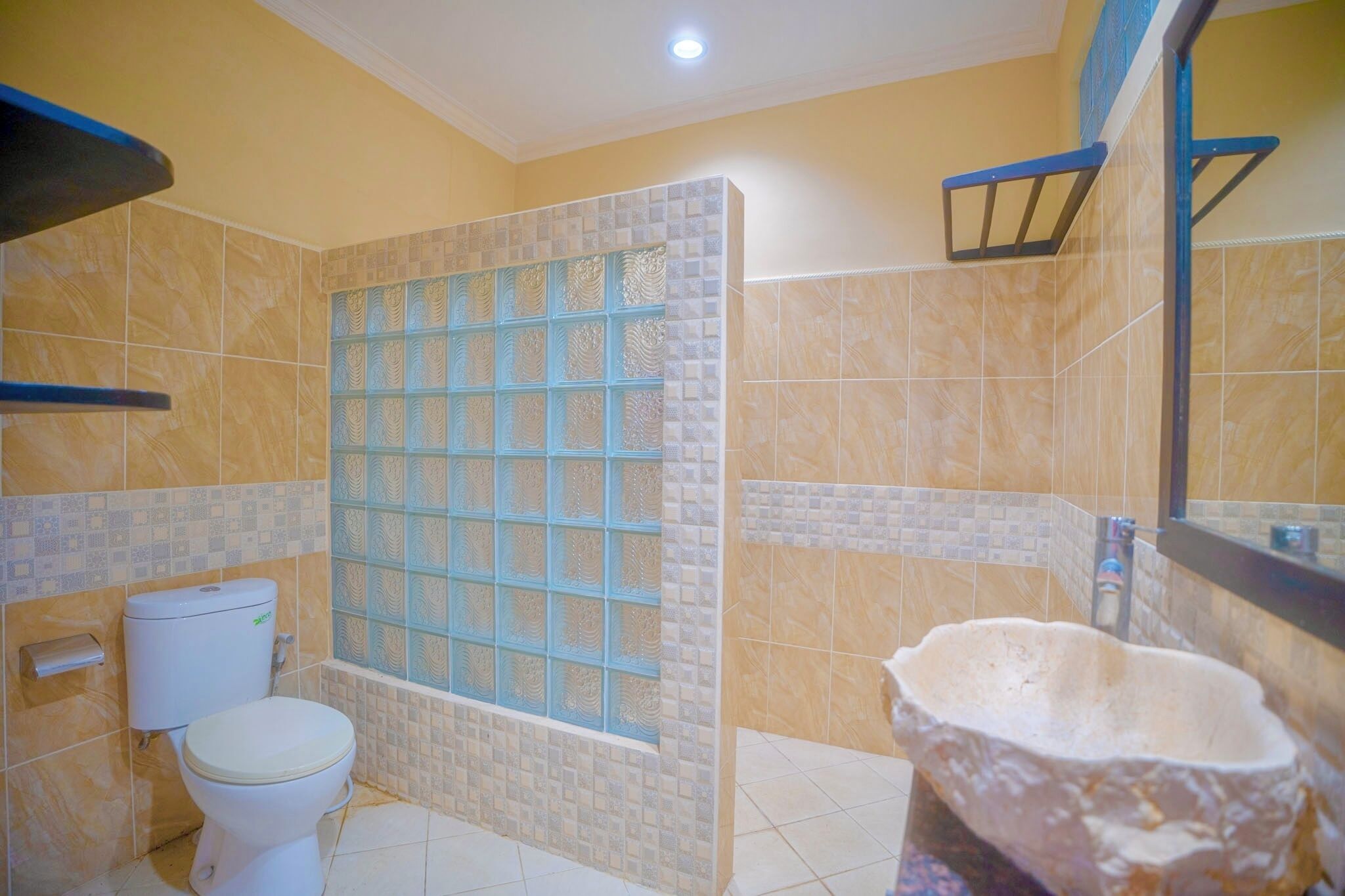 Un baño con ducha, inodoro y lavabo de piedra.