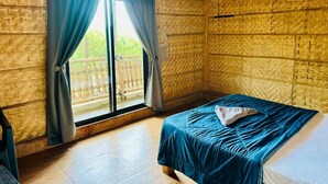 A room with a bed, a window with curtains, and a view of a balcony. - Bliss Hampi Eco Resort (Koppal)