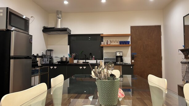 A modern kitchen with a central island, stainless steel appliances, and a dining area with a glass table and chairs. - Marvelous 3-bedroom house with AC in Inglewood (Inglewood)