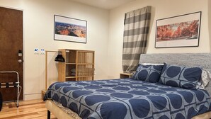 A bedroom with a wooden bed, a wooden wardrobe, a small bedside table, and two framed pictures on the wall. - Marvelous 3-bedroom house with AC in Inglewood (Inglewood)