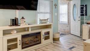 A living room with a fireplace, television, and decorative items. - Walk to Shore! Surfside Beach Gem w/ Game Courts (Surfside Beach)