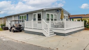 A single-story house with a front porch, a small deck, and a golf cart parked in front. - Walk to Shore! Surfside Beach Gem w/ Game Courts (Surfside Beach)