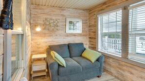 A cozy room with a grey sofa, a small white table, and a lamp. - Walk to Shore! Surfside Beach Gem w/ Game Courts (Surfside Beach)