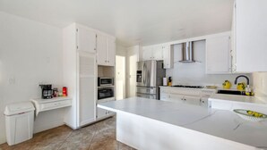 Una cocina moderna con armarios blancos, electrodomésticos de acero inoxidable y una isla grande.