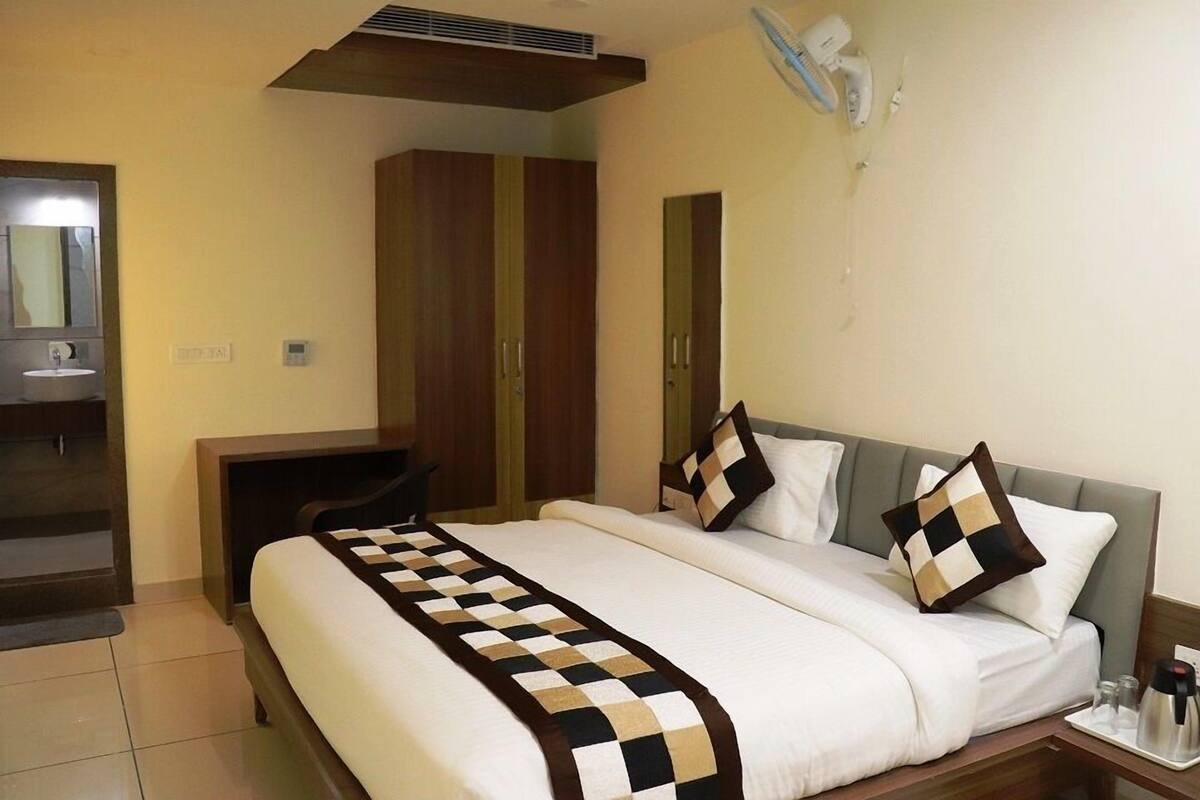A hotel room with a bed, a desk, and a wardrobe.
