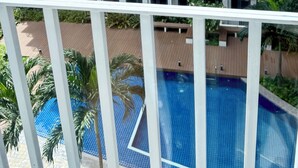 En flereetagers boligbygning med altaner og swimmingpool.