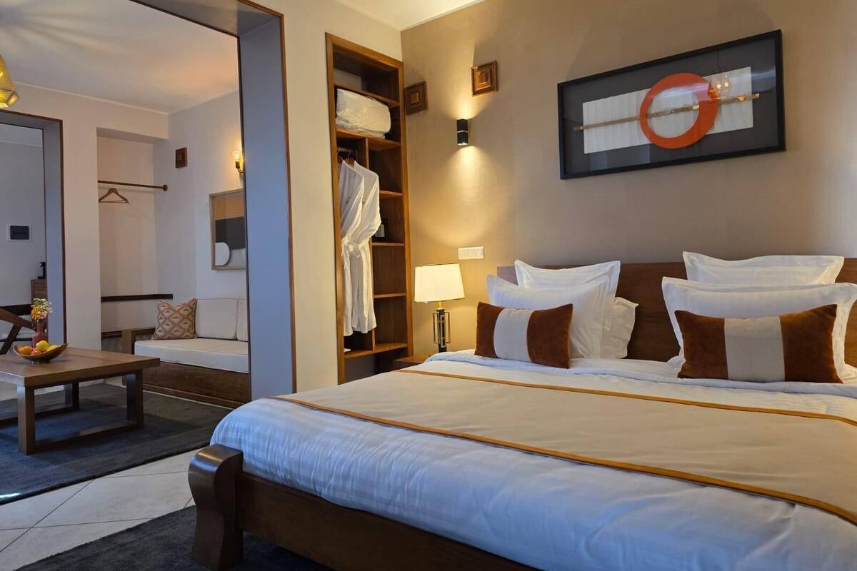 Een hotelkamer met een groot bed, een nachtkastje, een kledingkast en een spiegel.