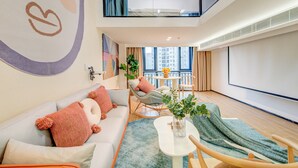 Uma sala de estar moderna com um sofá, cadeiras, uma mesa de centro e vista da cidade.