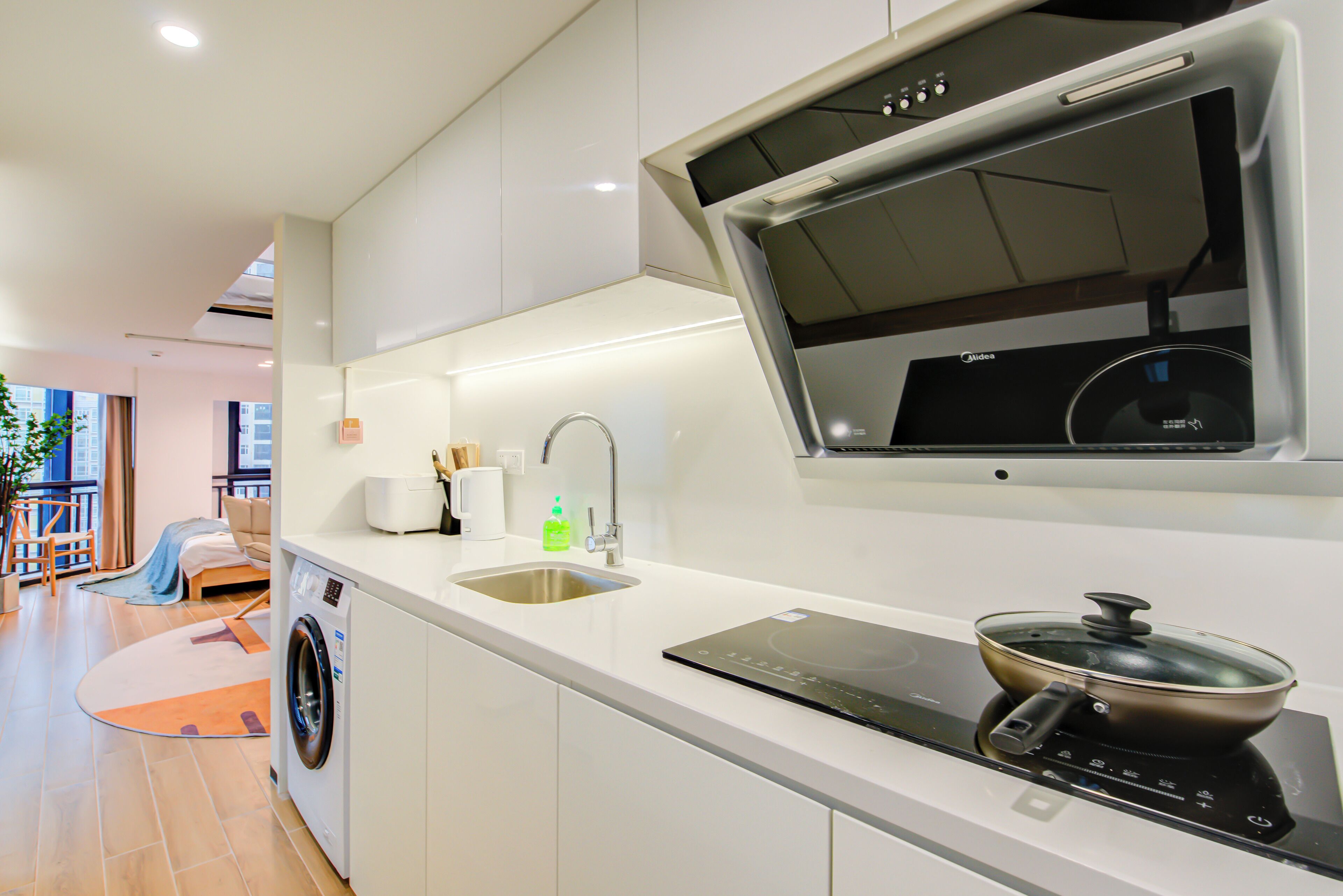 Una cocina moderna con lavadora integrada, un lavabo y una estufa.