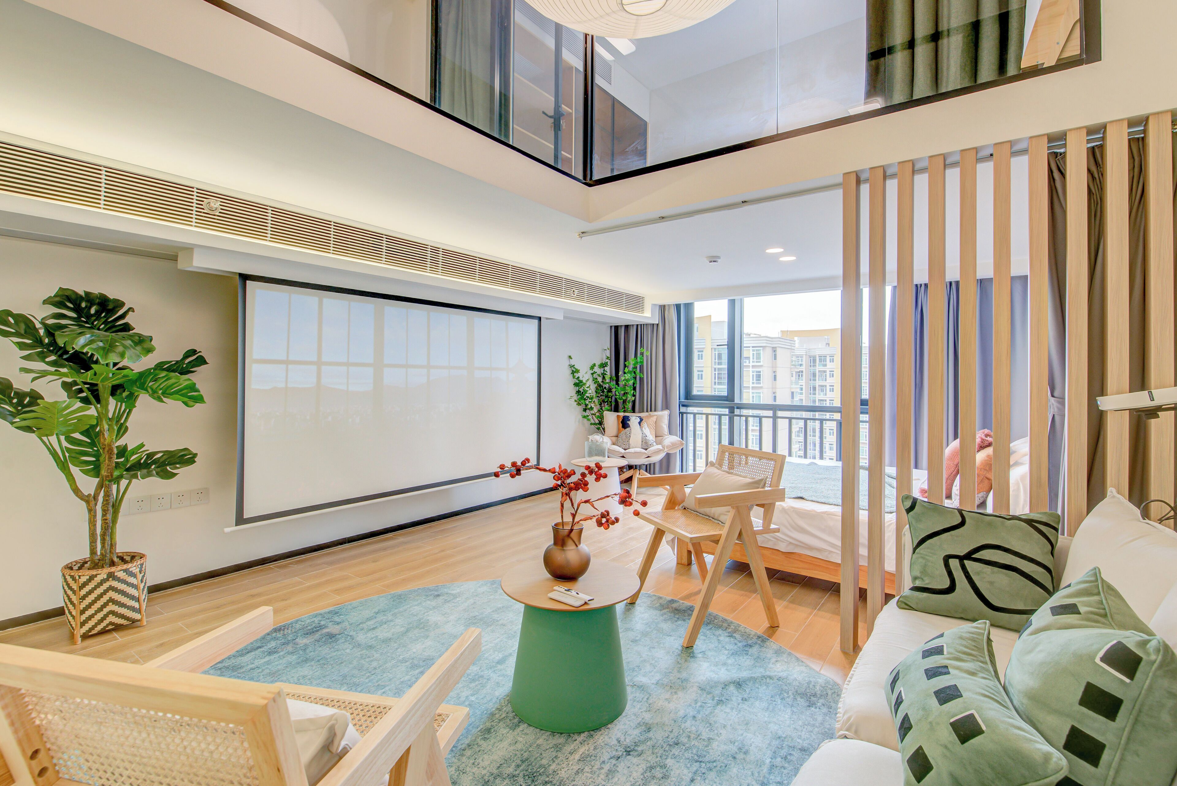 A modern living room with a large window, a green coffee table, and a view of the city.