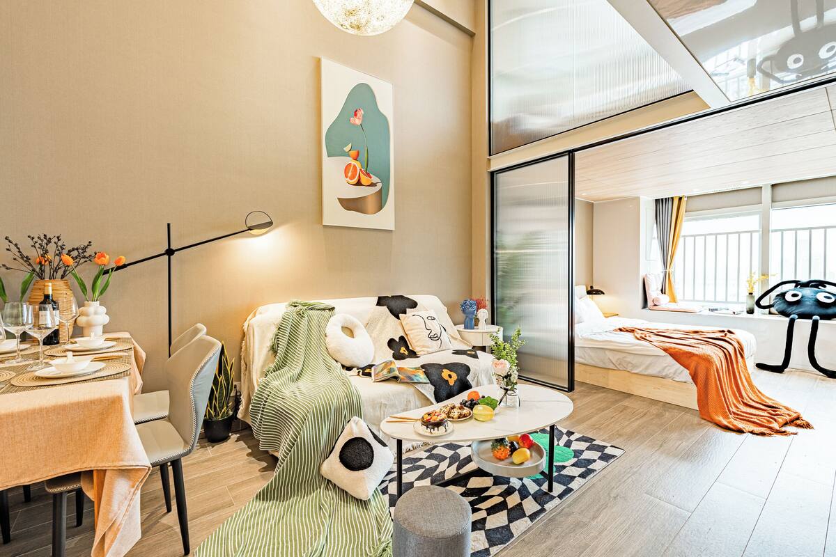 Ein modernes Wohnzimmer mit Sofa, Esstisch und Bett mit Blick.