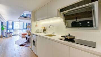 A modern kitchen with a built-in oven, a sink, and a window overlooking the city.