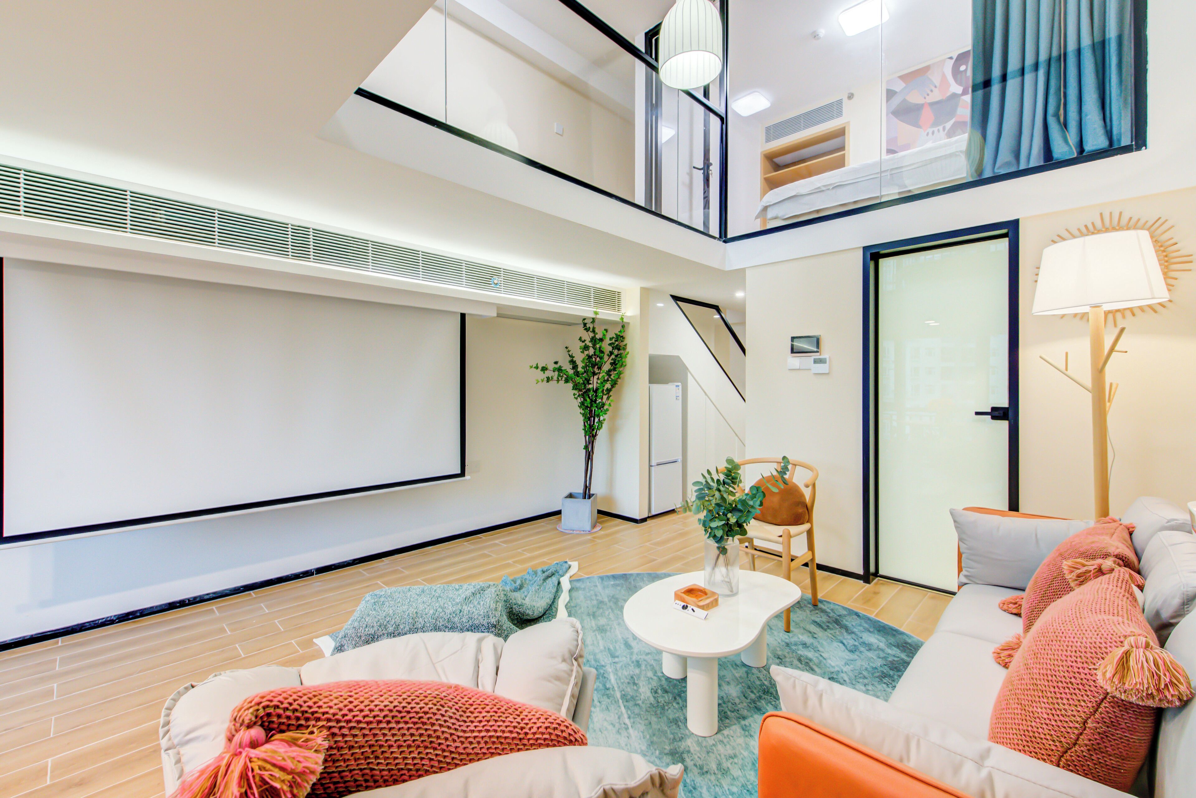 A modern living room with a sofa, a coffee table, and a TV screen.