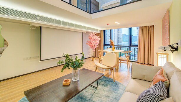 Uma sala de estar moderna com um sofá, mesa de centro e área de jantar com mesa e cadeiras.