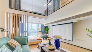 Uma sala de estar moderna com um sofá, mesa de centro e uma cama.