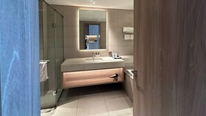 Une salle de bain moderne avec un grand miroir, un lavabo en marbre et un meuble-lavabo en bois.
