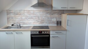 Una cocina moderna con salpicadero de madera, electrodomésticos de acero inoxidable y armarios blancos.