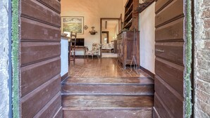 Eine Holztreppe führt zu einem Raum mit Fernseher, einem Sessel und einem Tisch.