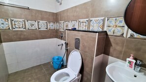 A bathroom with a toilet, sink, and shower. - Crescent Stays Financial District (Hyderabad)