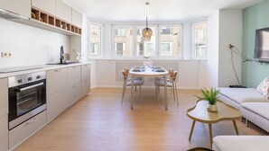 Una cocina moderna con comedor, ventanas amplias y un rincón de estar acogedor.