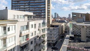 Un edificio alto con varios balcones y un paisaje urbano al fondo.