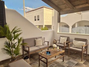 A covered outdoor seating area with a sofa, chairs, and a coffee table, featuring a potted plant and a decorative vase. - Beautiful apartment for 4 people with A/C, WIFI, TV and veranda, close to Ostuni (Specchiolla)
