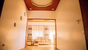 A living room with a sofa, a coffee table, and a ceiling with recessed lighting. - Breeze House Gikondo (Kigali)