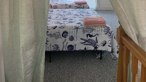 A room with a bed, a wooden headboard, and a window with curtains. - Mermaid's and Mutts Retreat - 30 Day Listing (Norfolk)