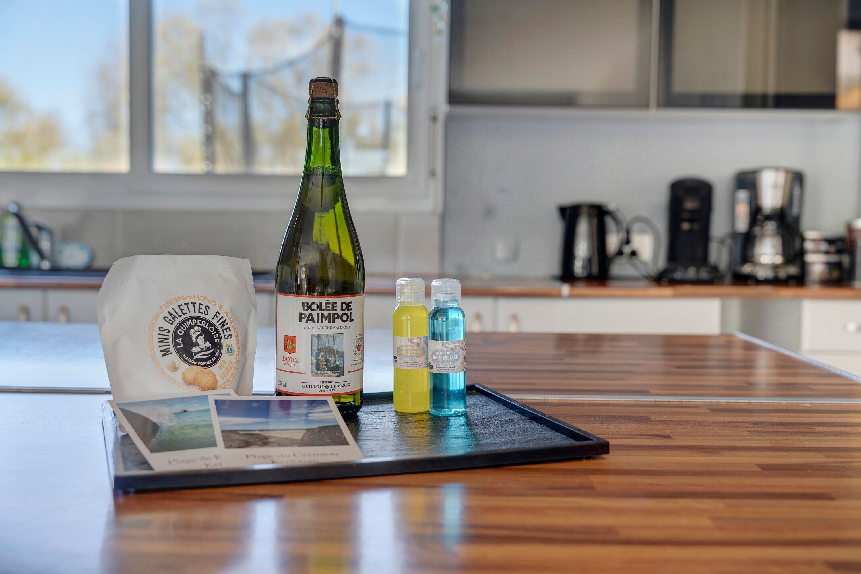 Een aanrecht met een fles wijn, een zak snacks en twee kleine flessen vloeistof.