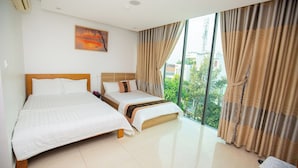 A hotel room with two beds, a large window with curtains, a painting on the wall, and a view of buildings outside. - The Sóng - Ruby Star Hotel Apartment (Ho Chi Minh City)