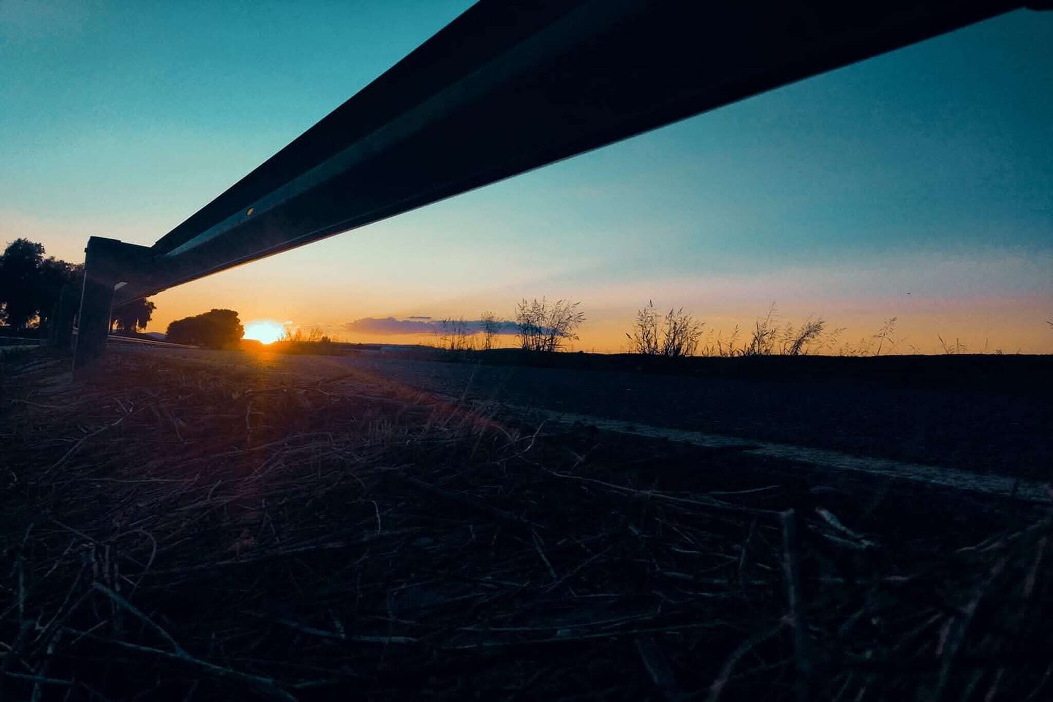 Solnedgang over bro med klar himmel.